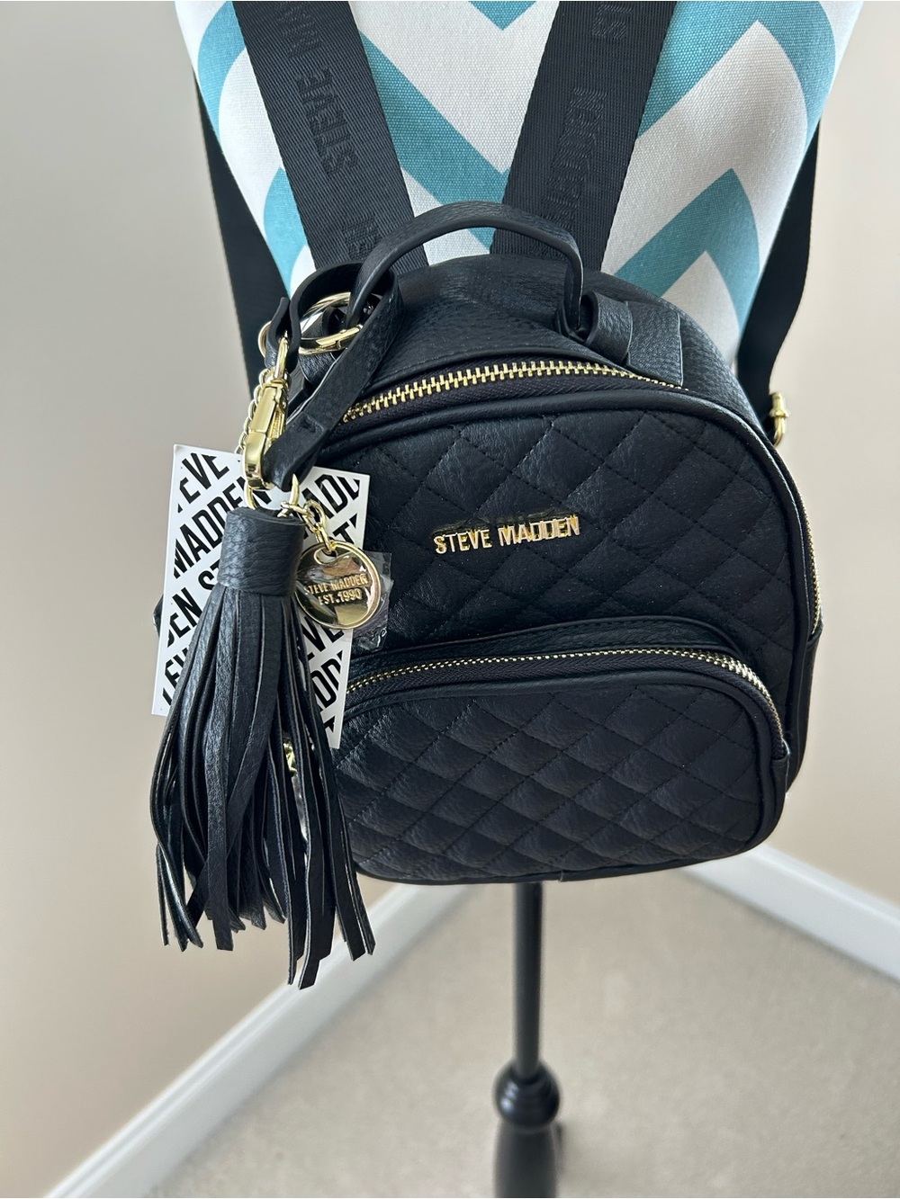 Steve Madden Black Quilted Mini Backpack with Tassel Charm and Gold Hardware